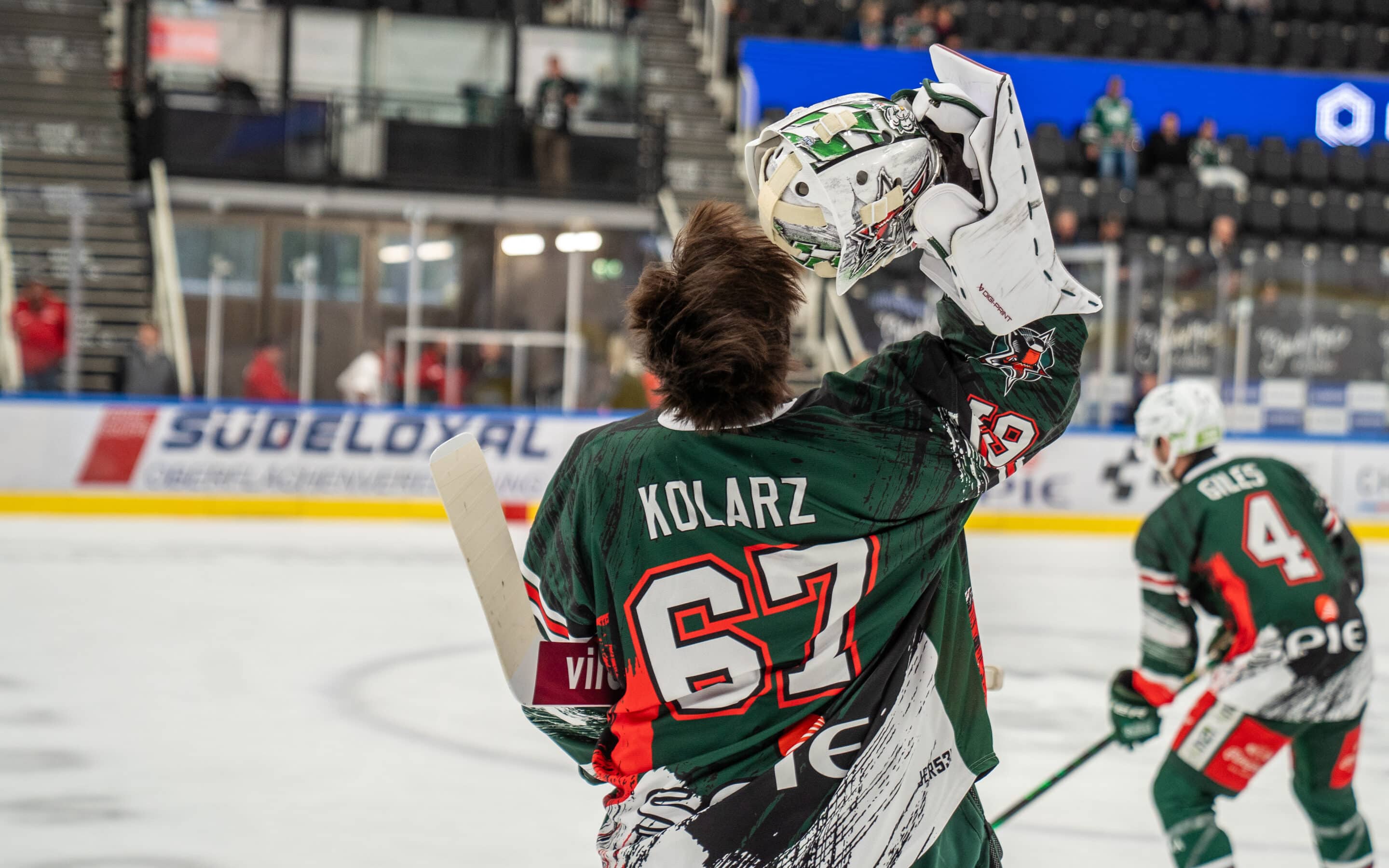 Christopher Kolarz (#67), Starbulls Rosenheim, nimmt mit der Fanghand seine Torhütermaske ab.